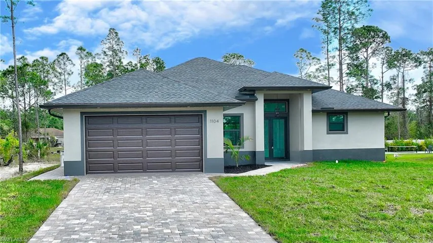View of front of home with a garage and a front yard