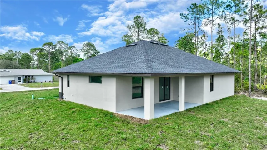 Back of property featuring a patio area and a lawn
