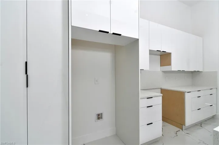 Kitchen with decorative backsplash and white cabinets