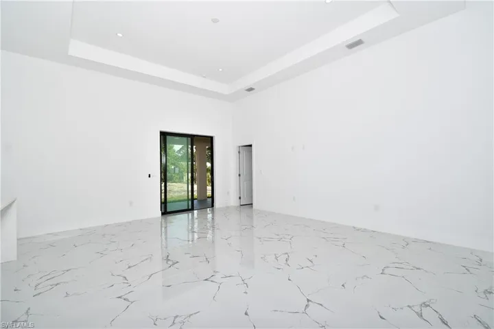 Unfurnished room with a tray ceiling and a high ceiling