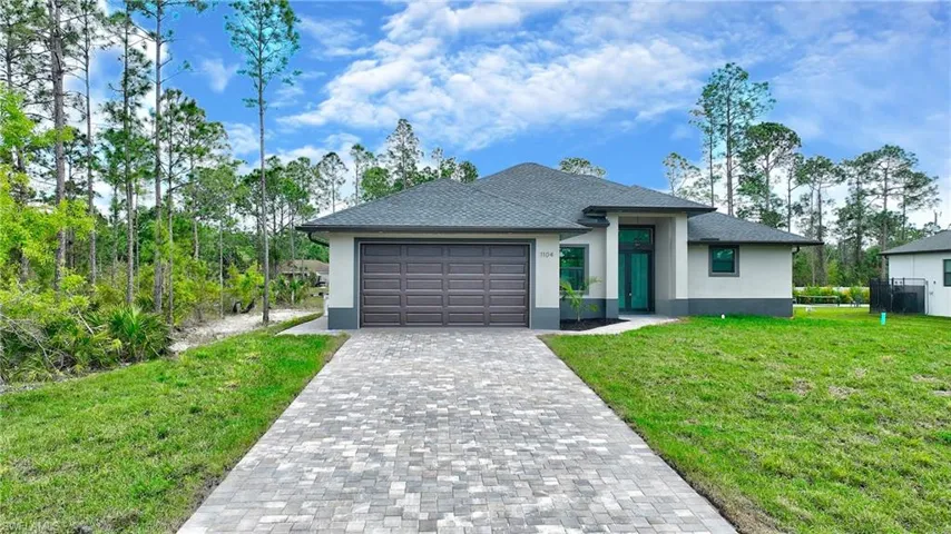 View of front of home featuring a garage and a front yard