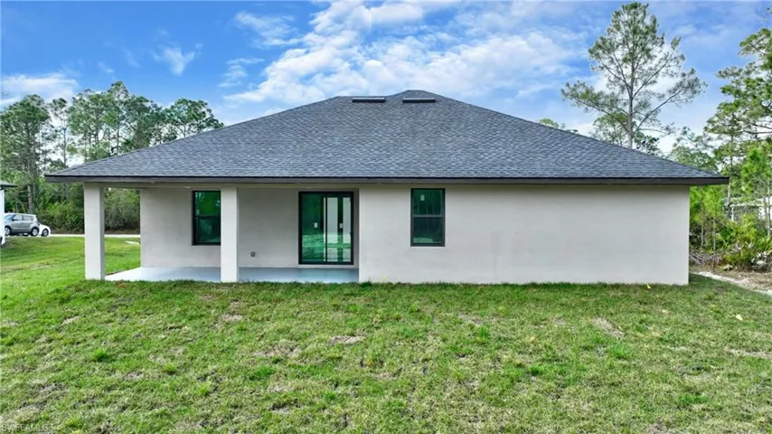 Rear view of property with a patio area and a yard