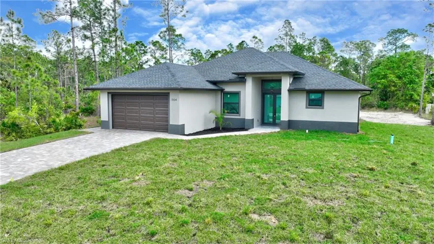 View of front of house with a front lawn and a garage