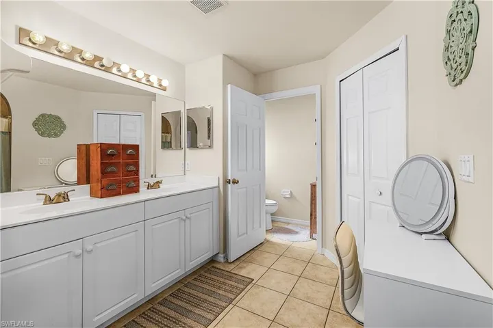 Dining space with a ceiling fan, tile patterned floors, and vaulted ceiling