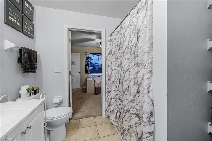 Carpeted bedroom featuring baseboards, closet, and ceiling fan