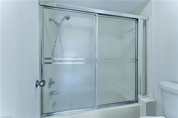 Bathroom featuring shower / bath combination with glass door
