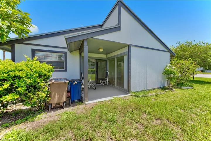 Rear view of property with a lawn and a patio