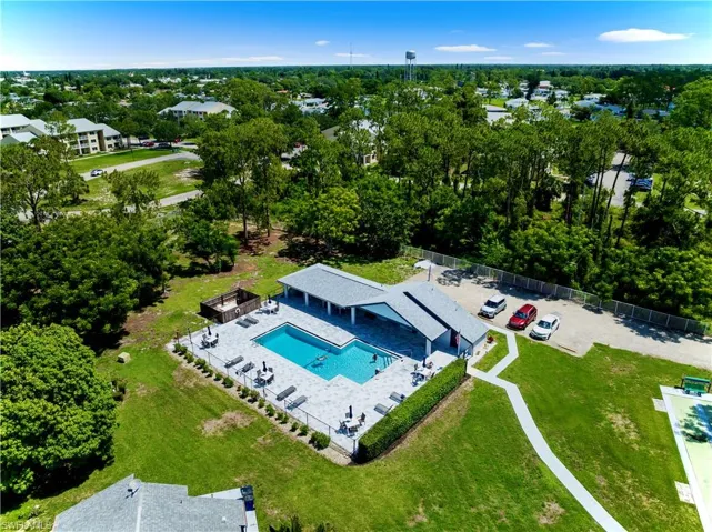 Drone / aerial view of a pool and a tree filled landscape