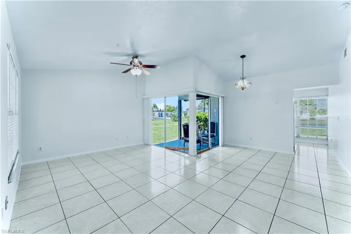Unfurnished room with light tile patterned floors, vaulted ceiling, a ceiling fan, and french doors