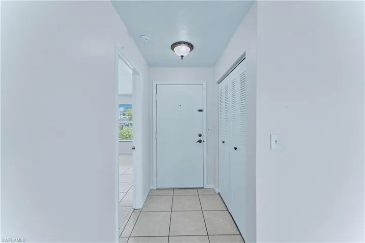 Doorway to outside featuring light tile patterned floors and baseboards
