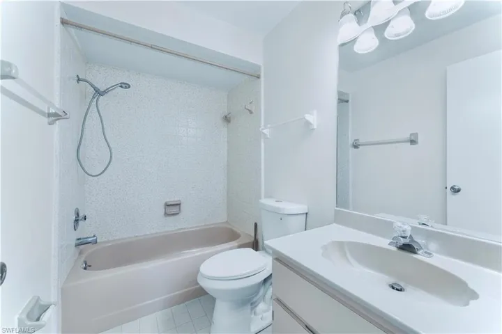 Full bath with bathtub / shower combination, vanity, and tile patterned flooring