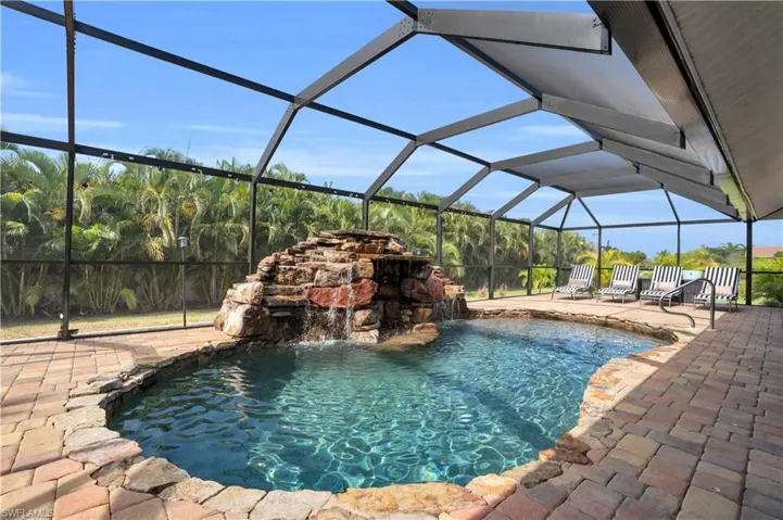 Outdoor pool with glass enclosure, a sunroom, and a patio area