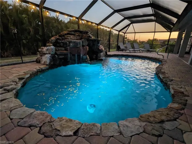 Swimming pool with a sunroom, a lanai, and a patio