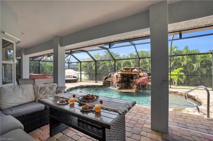 View of patio / terrace featuring glass enclosure, an outdoor pool, a sunroom, and a hot tub