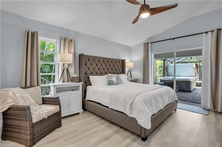 Bedroom with light wood-style flooring, access to exterior, lofted ceiling, and ceiling fan