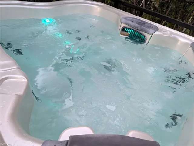 View of swimming pool with a hot tub