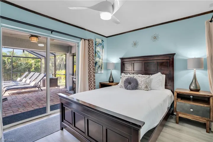 Bedroom featuring crown molding, a sunroom, light wood-style floors, access to outside, and a ceiling fan