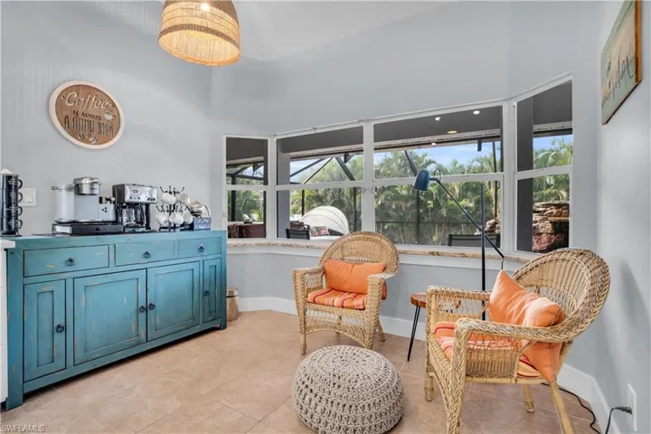 Living area featuring light tile patterned floors and a high ceiling
