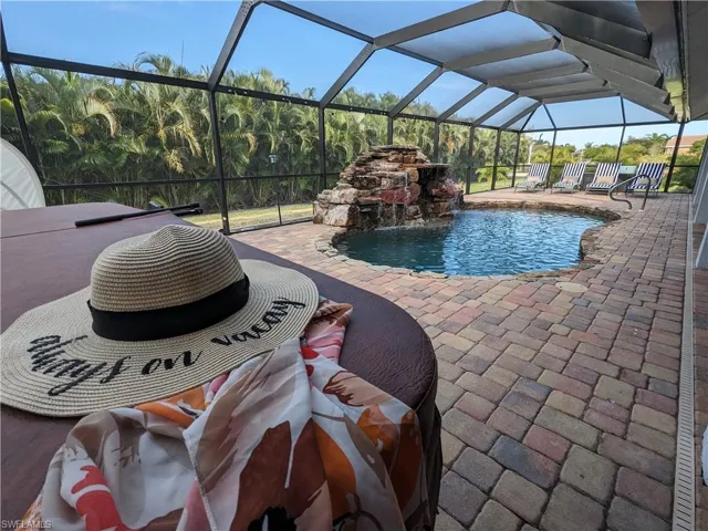 Outdoor pool with a sunroom, a lanai, and a patio