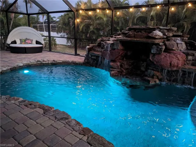 Outdoor pool featuring a sunroom and a lanai