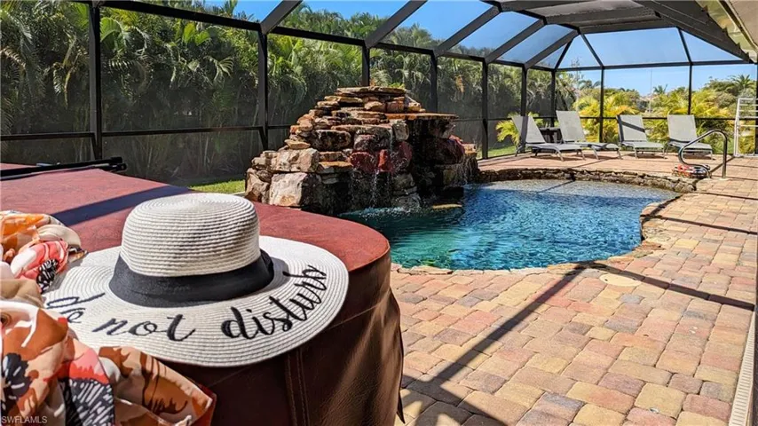 Swimming pool featuring glass enclosure, a sunroom, and a patio area
