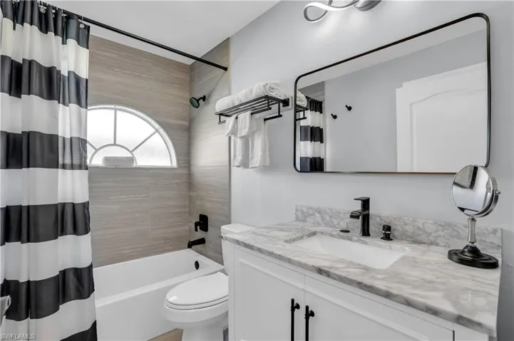 Bathroom featuring shower / bath combination with curtain and vanity