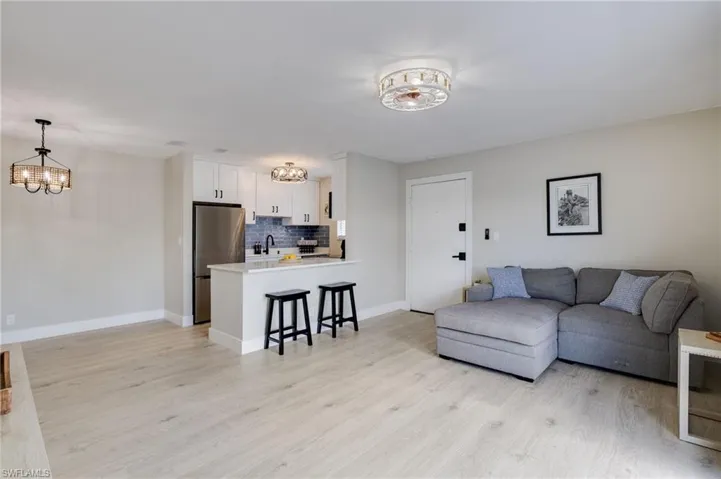 Living area with suspended lighting and light wood finished floors