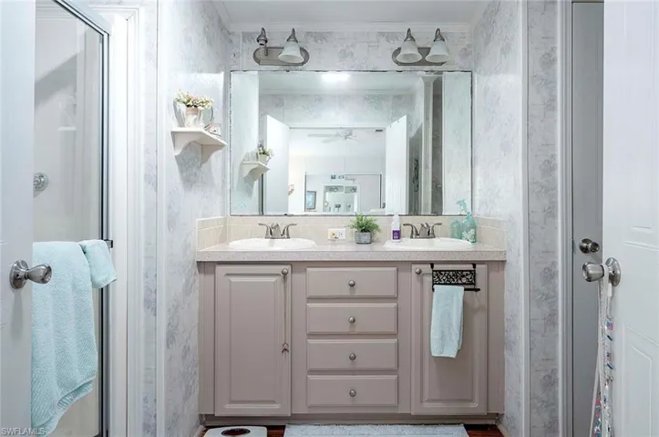 Bathroom with ornamental molding and dual bowl vanity