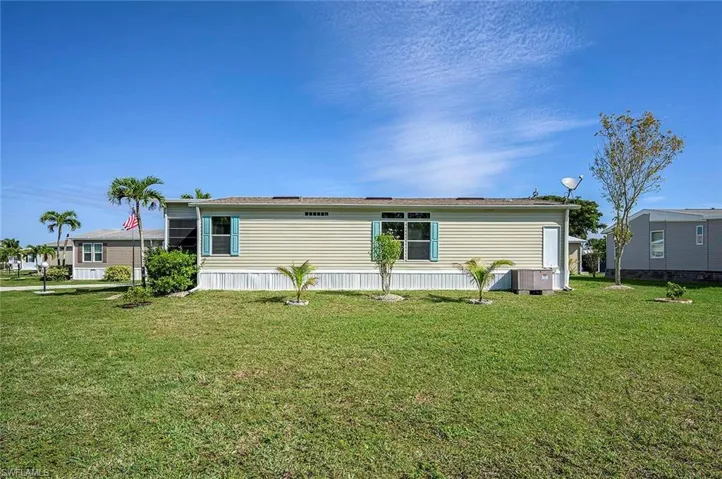 Rear view of property with a yard