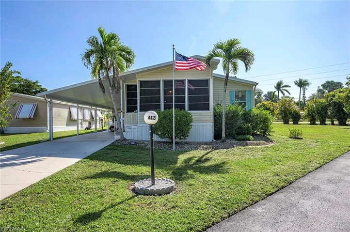 Manufactured / mobile home with a carport and a front yard