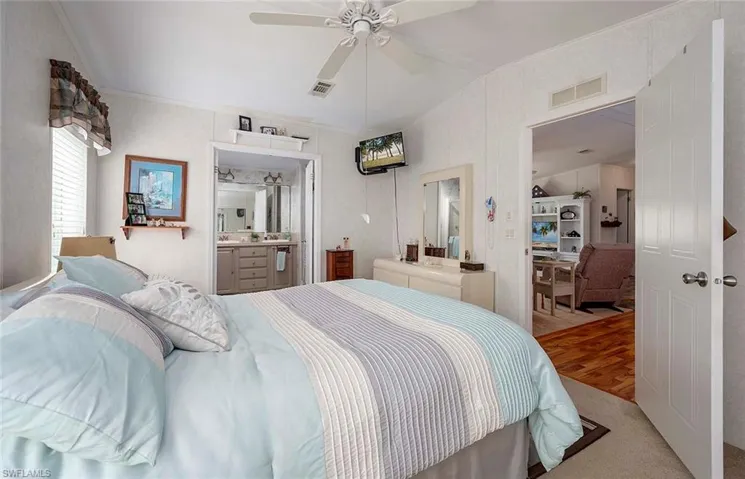 Bedroom featuring ceiling fan, connected bathroom, and wood-type flooring