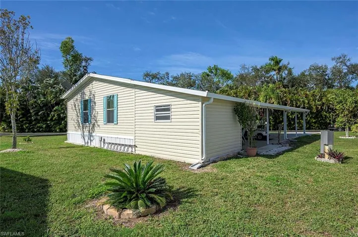View of side of home featuring a patio and a yard