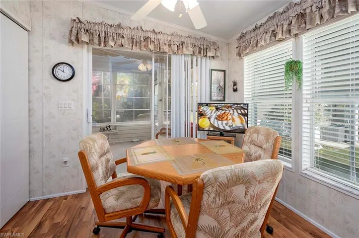 Dining space featuring a wealth of natural light, ceiling fan, ornamental molding, and wood-type flooring