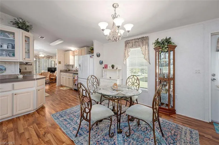 Dining space featuring light hardwood / wood-style floors, crown molding, and an inviting chandelier