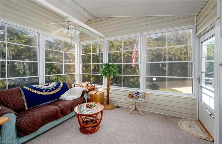Sunroom featuring ceiling fan and vaulted ceiling with beams