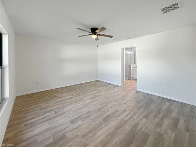 Empty room with light wood-style floors and ceiling fan