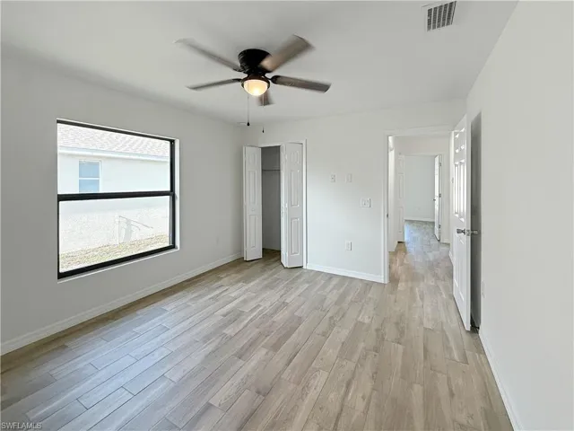 Unfurnished bedroom with light wood finished floors, a ceiling fan, and a closet