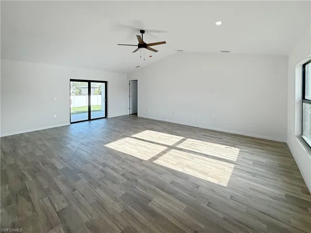 Unfurnished room featuring light wood finished floors, vaulted ceiling, and a ceiling fan