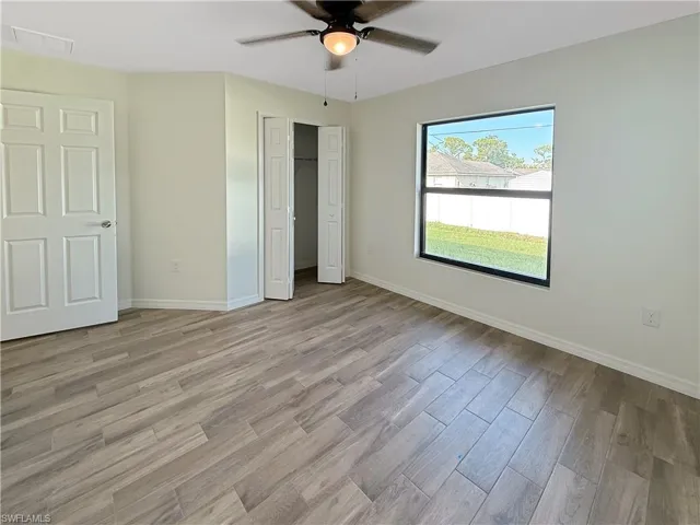 Unfurnished bedroom with light wood-style floors, ceiling fan, and a closet