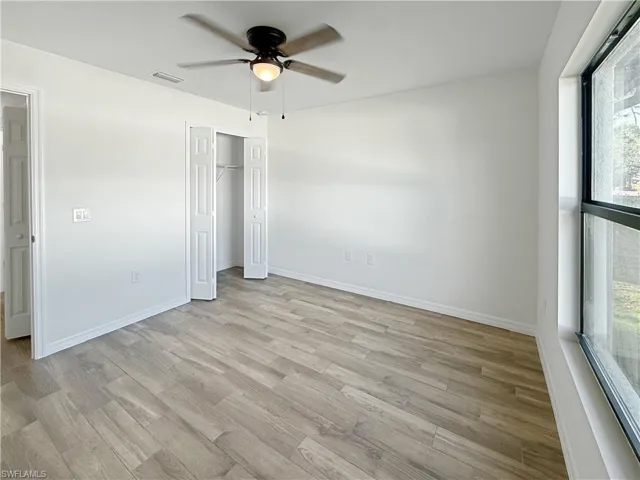 Unfurnished bedroom with light wood-type flooring, a ceiling fan, and a closet