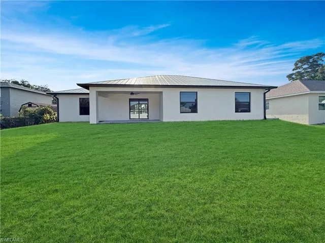 Back of property with stucco siding, a yard, and a patio area