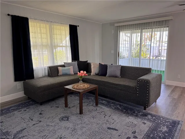 Living room with laminate flooring, slider access to front sunroom