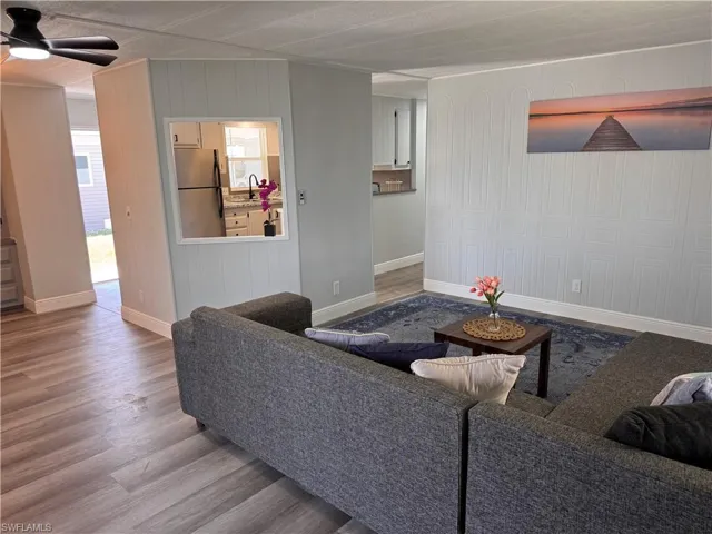 Living room view of kitchen and dining.  Decorative accent wall, laminate flooring