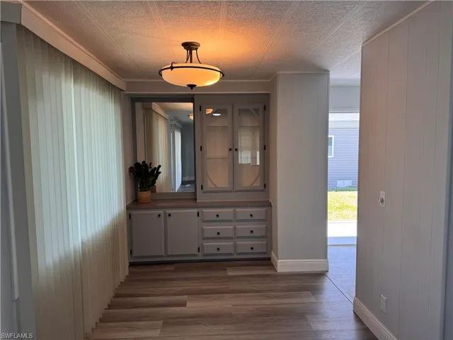 Dining area with built in credenza and overhead lighting, windows looks out into sunroom