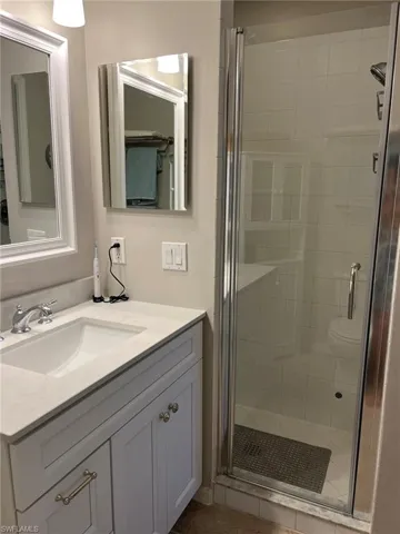 Bathroom with walk in shower, oversized vanity, and toilet