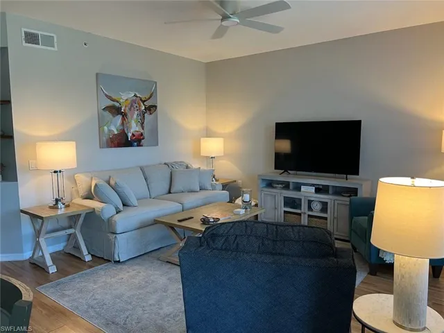 Living room featuring ceiling fan and hardwood / wood-style flooring
