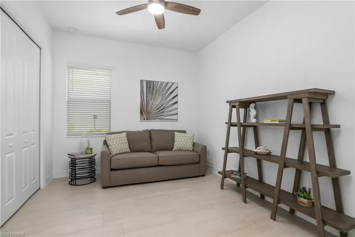Living area with a ceiling fan and baseboards