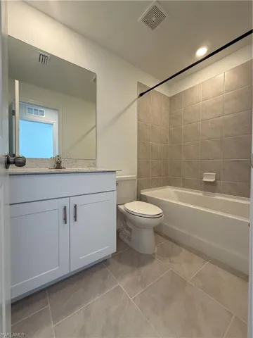 Bathroom with  shower combination, vanity, and light tile patterned flooring