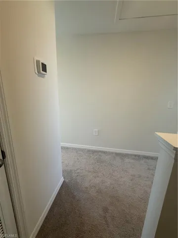 Hall featuring carpet flooring and baseboards