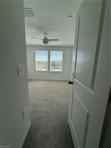 Spare room with light colored carpet and ceiling fan